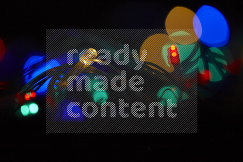Light bulbs glowing against backdrop of multicolord bokeh