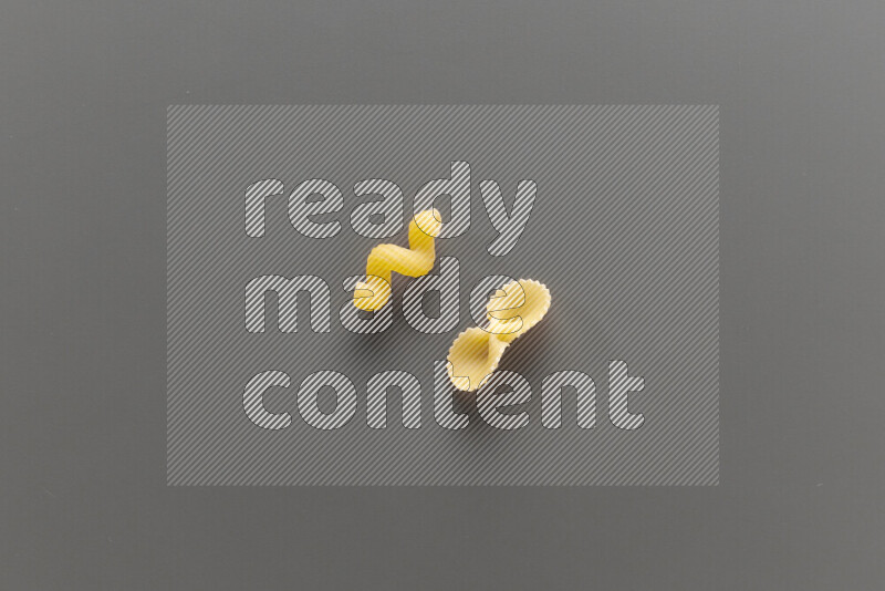 Twist pasta with other types of pasta on grey background