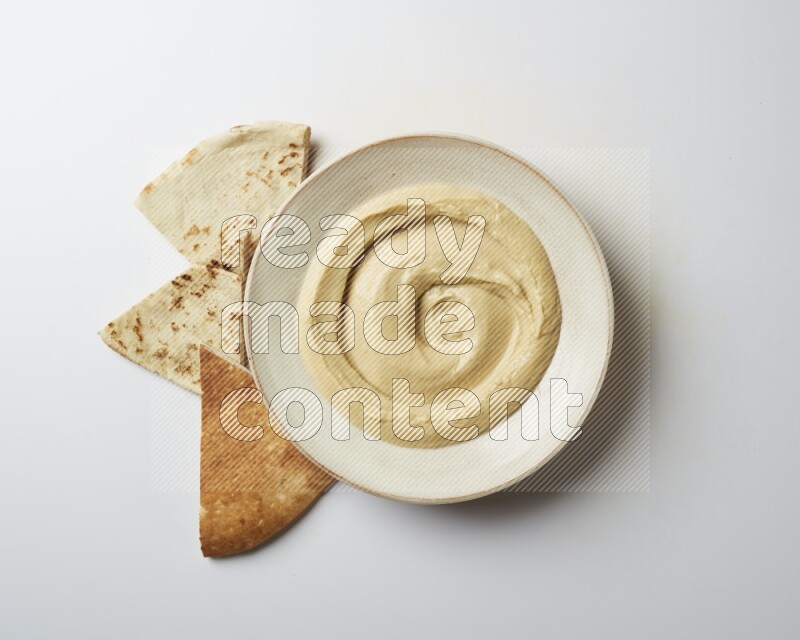plain Hummus in a pottry plate  on a white background
