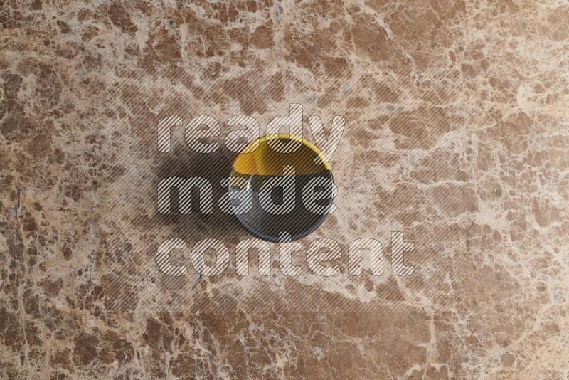 A multicolored pottery bowl on beige marble background