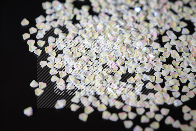 Colorful plastic shards for decoration scattered on a black background