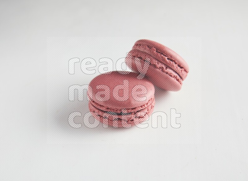 45º Shot of two Pink Raspberry macarons on white background
