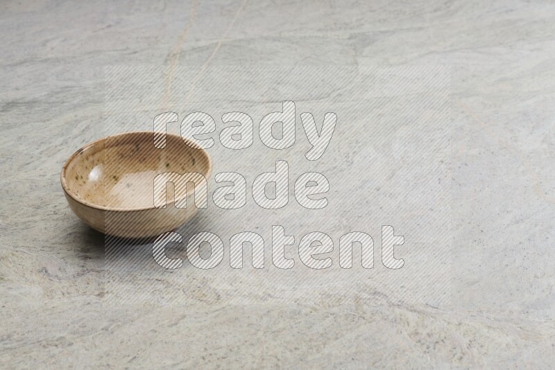 A multicolored pottery bowl on grey marble background