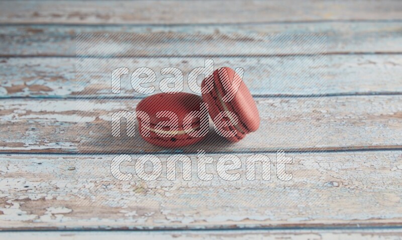 45º Shot of two Red Velvet macarons on light blue wooden background