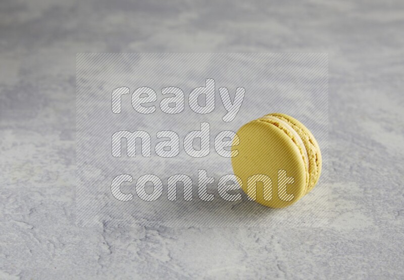 45º Shot of Yellow Lime macaron on white marble