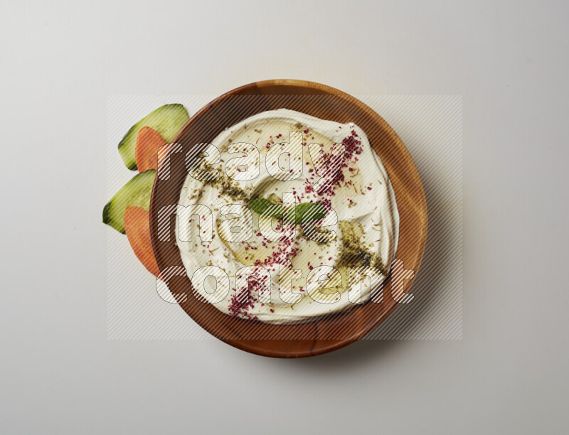 Lebnah garnished with  zattar , sumak & mint in a wooden plate on a white background