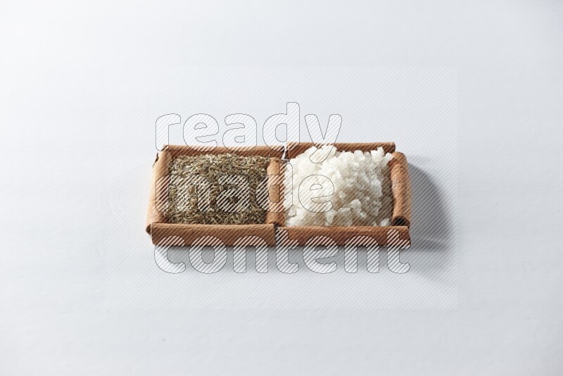 2 squares of cinnamon sticks full of white salt and cumin on white flooring