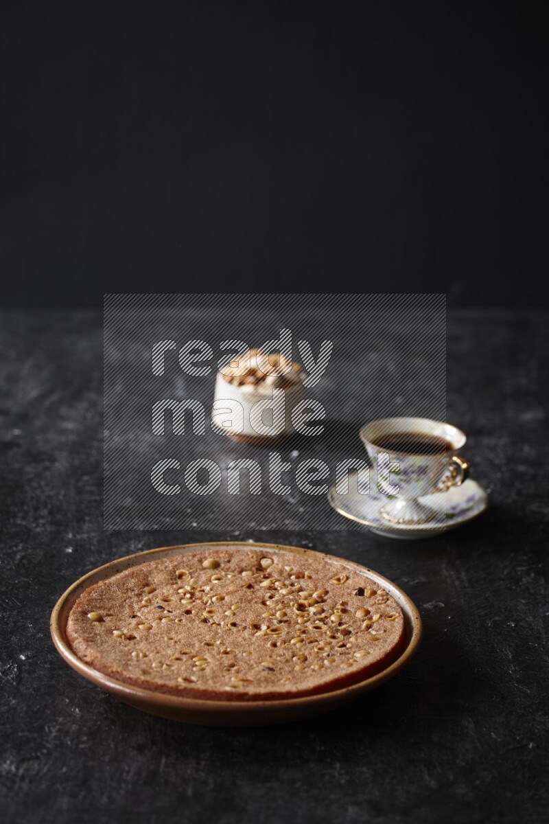 Basbousa with nuts and tea in a dark setup