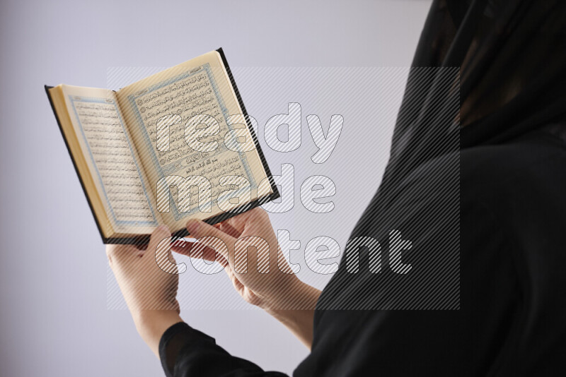 A woman hands holding moshaf in different positions