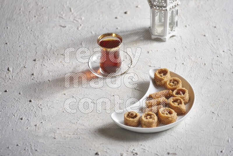 Konafa in a pottery plate with lantern and tea in a light setup