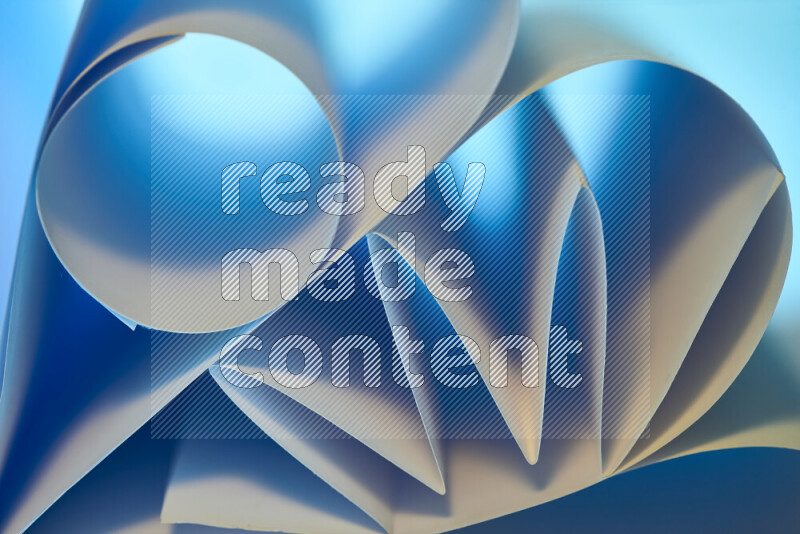 An artistic display of paper folds creating a harmonious blend of geometric shapes, highlighted by soft lighting in blue and warm tones