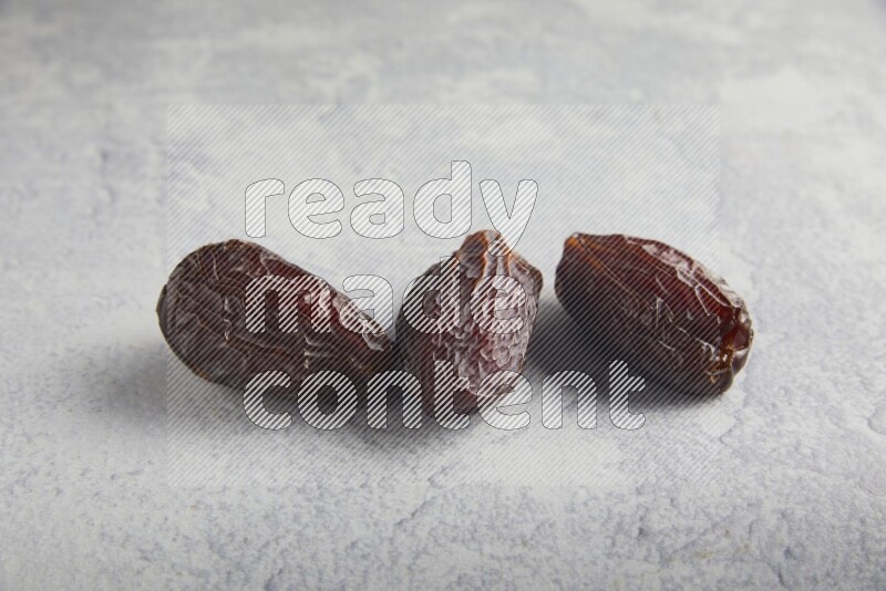 three madjoul dates on a light grey background