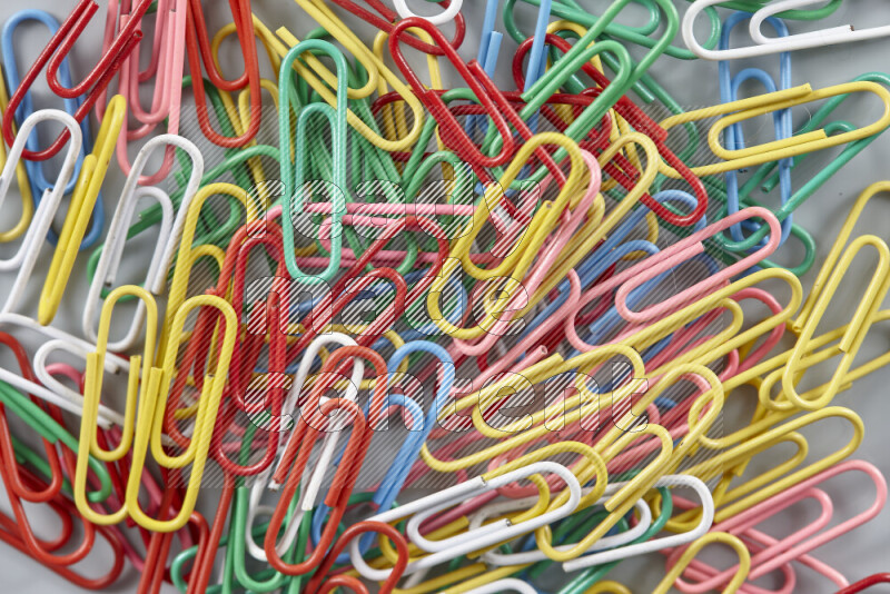 Multicolored paper clips isolated on a grey background