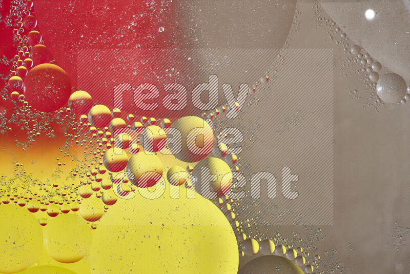 Close-ups of abstract oil bubbles on water surface in shades of yellow, red and brown