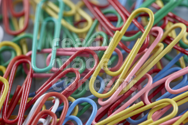 Multicolored paper clips isolated on a grey background