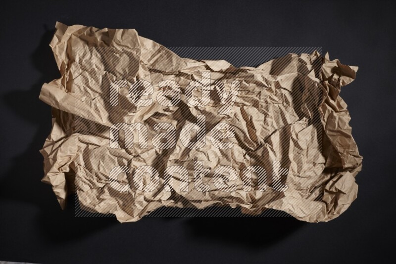 Crumpled craft paper on black background