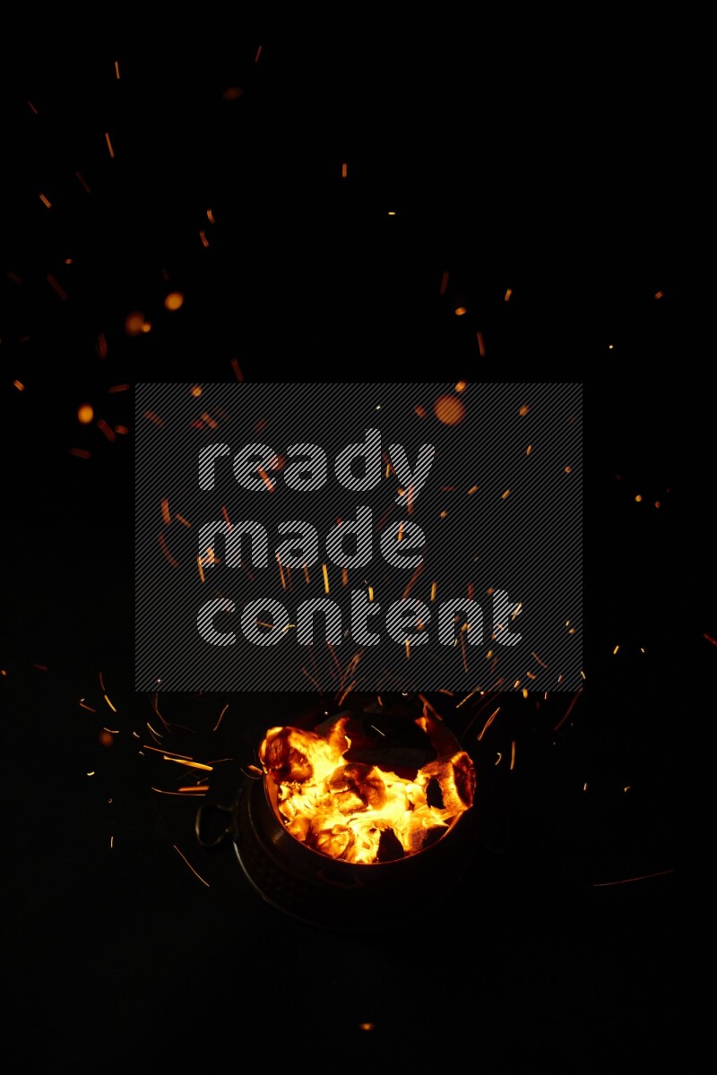 Coal cubes on fire in metal pan