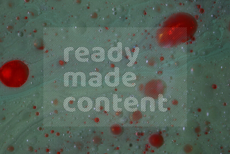 The image captures a dramatic splatter of red paint over a green backdrop