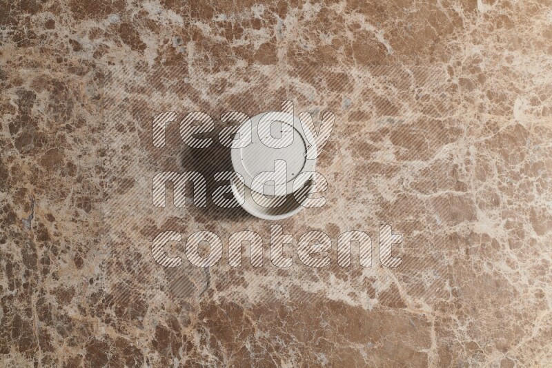 A pottery cup on beige marble background