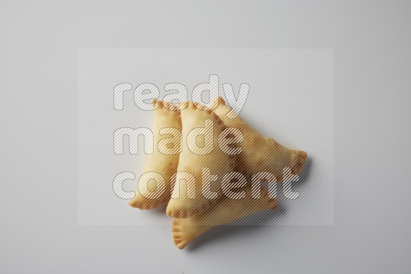 Four fried sambosa from a top angle on a white background