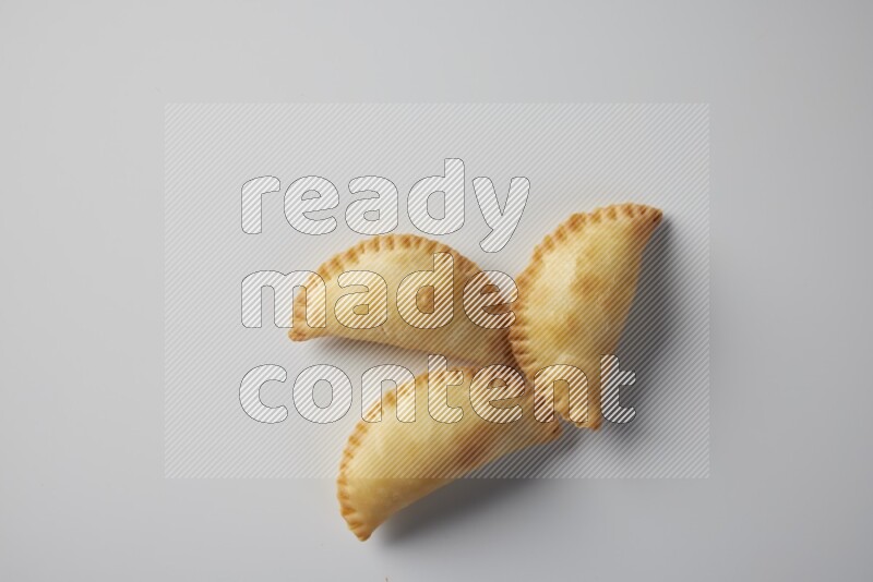 Three fried sambosa from a top angle on a white background