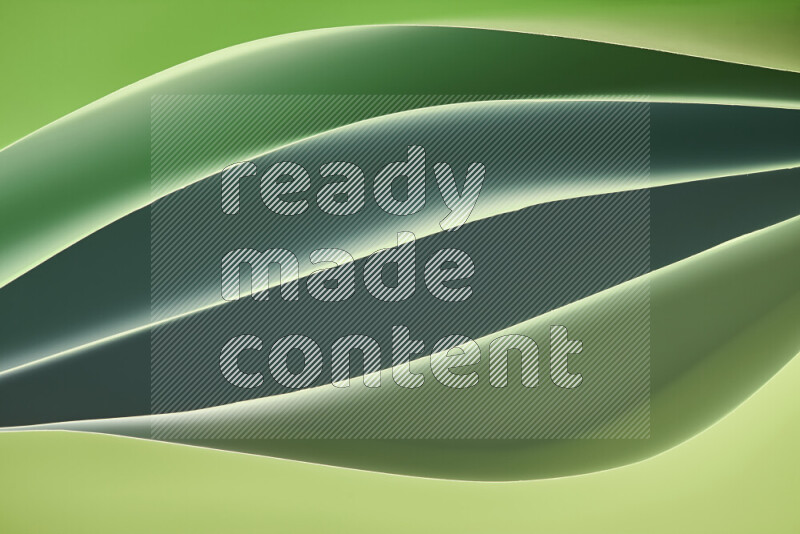 This image showcases an abstract paper art composition with paper curves in green gradients created by colored light