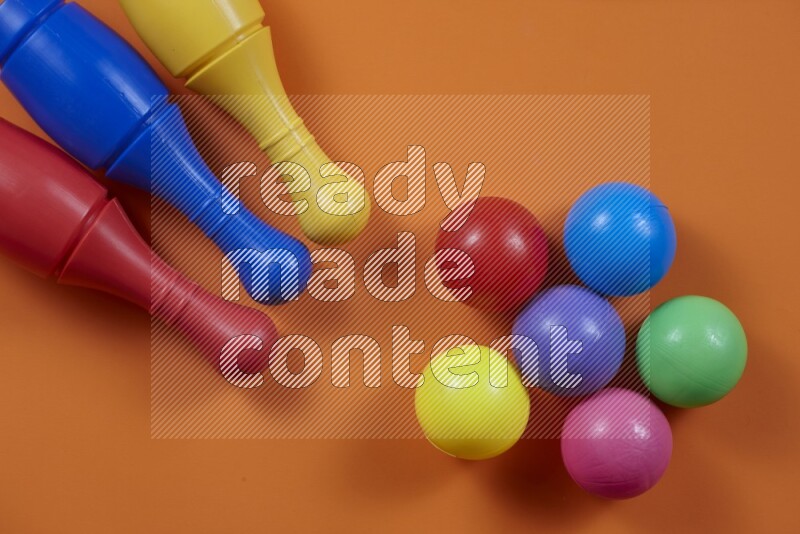 Plastic bowling pins with balls on different colored backgrounds (kids toys)