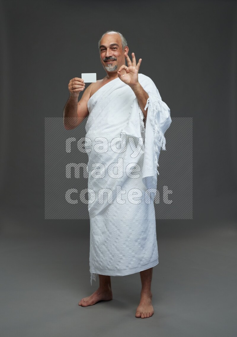 A man wearing Ehram Standing holding ATM card on gray background