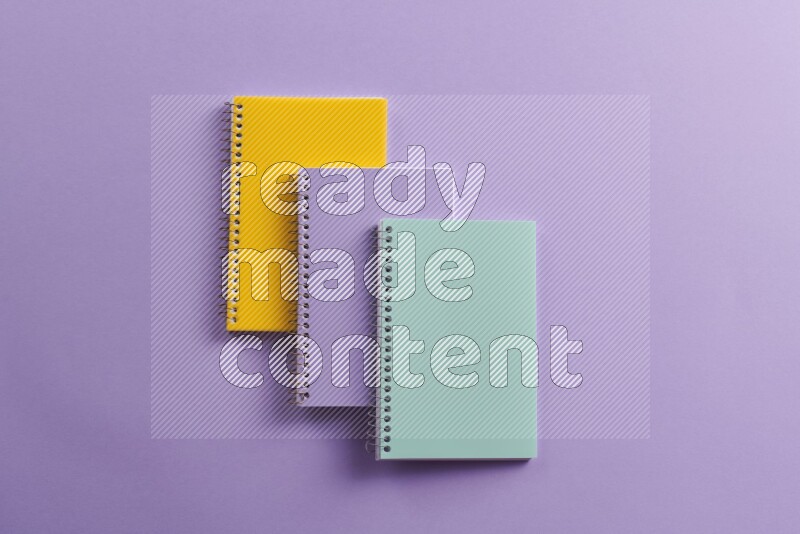 Multicolored notebooks on purple background