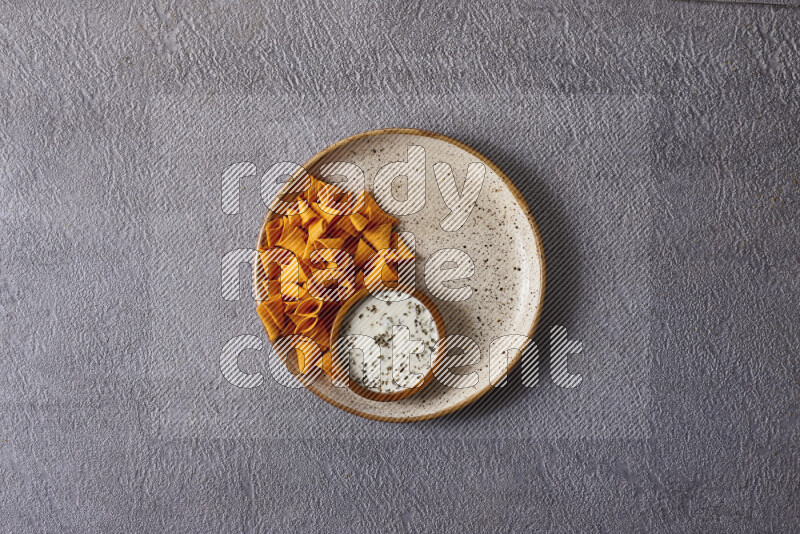 Assorted snacks in pottery bowls on grey background
