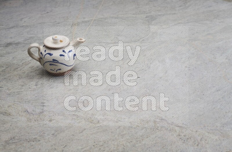 A pottery teapot on grey marble background