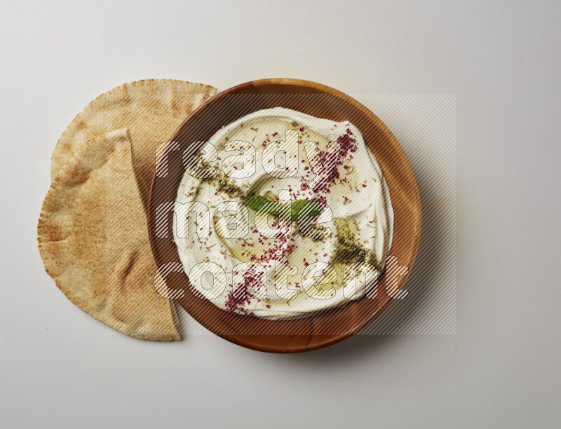 Lebnah garnished with  zattar , sumak & mint in a wooden plate on a white background