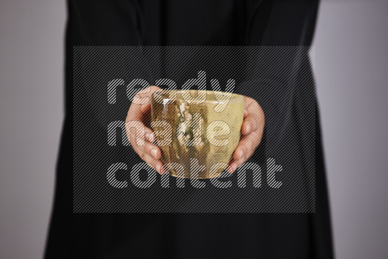A woman in black abaya holding different pottery essentials in different positions