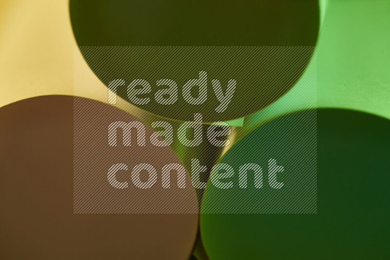 The image shows an abstract paper art with circular shapes in varying shades of green and warm tones