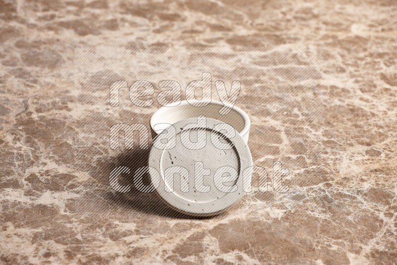 A white pottery bowl on beige marble background
