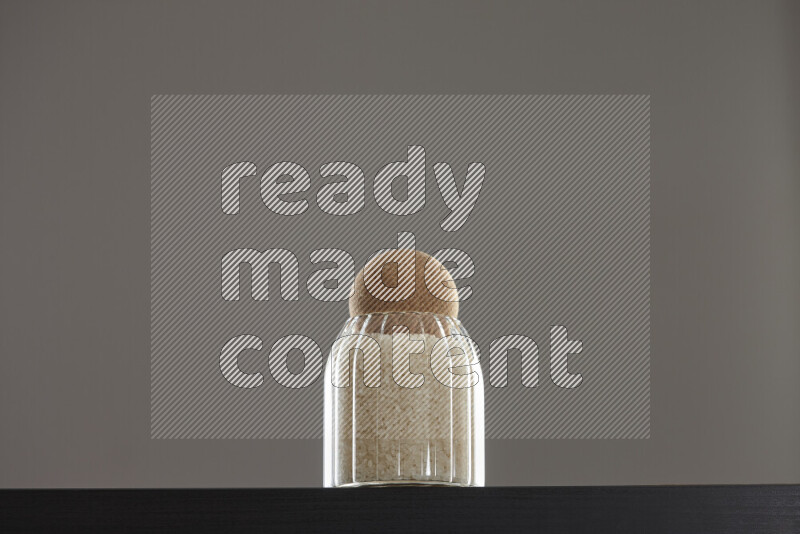 White rice in a glass jar on black background