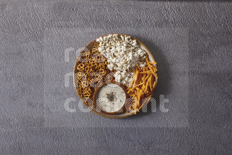 Assorted snacks in pottery bowls on grey background