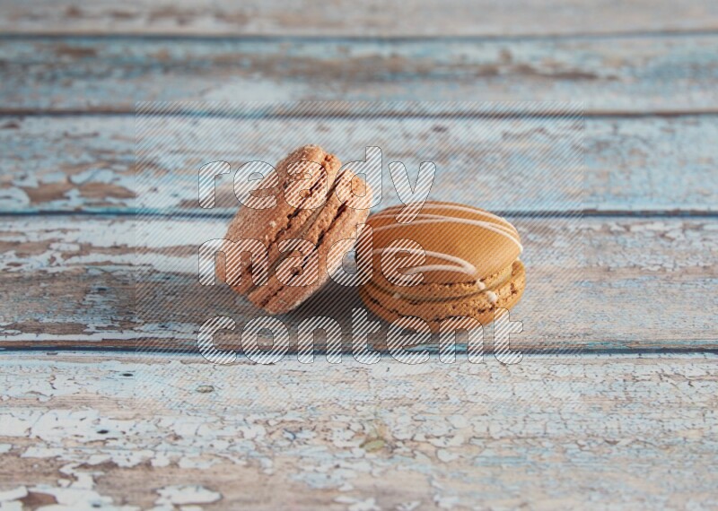45º Shot of of two assorted Brown Irish Cream, and Brown Hazelnuts macarons  on light blue background