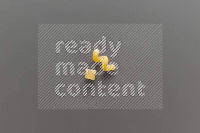 Big rings pasta with other types of pasta on grey background