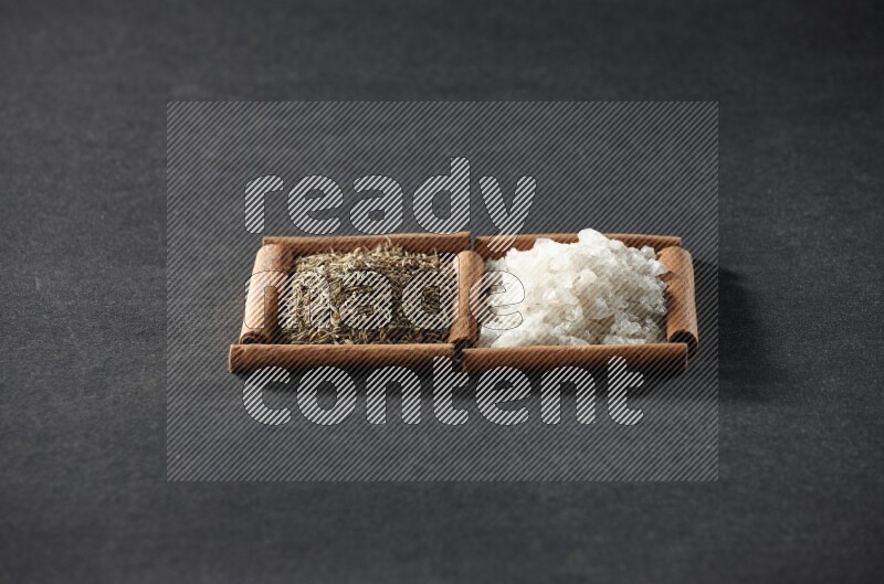 2 squares of cinnamon sticks full of white salt and cumin on black flooring