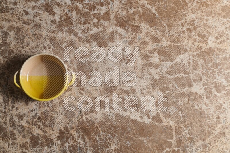 A multicolored pottery bowl on beige marble background