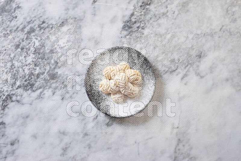 Kahk in black pottery plate on grey marble background