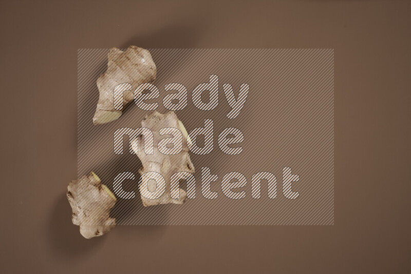 بهارات كاملة متنوعة تتضمن زنجبيل طازج ومجفف، أعواد قرفة، هيل، أصابع كركم، قرنفل، يانسون نجمي على خلفية بيج