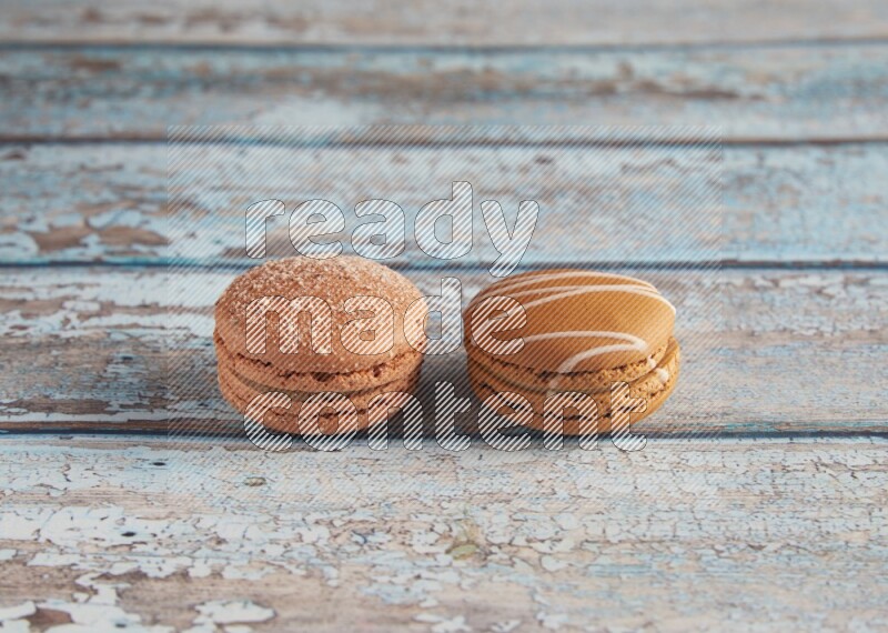 45º Shot of of two assorted Brown Irish Cream, and Brown Hazelnuts macarons  on light blue background
