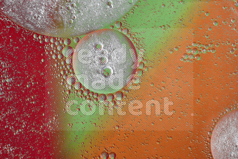 Close-ups of abstract oil bubbles on water surface in shades of orange, green and red