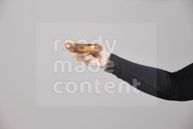 A woman in black abaya holding different wooden essentials in different positions