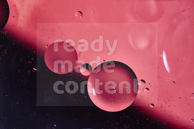 Close-ups of abstract oil bubbles on water surface in shades of black and pink