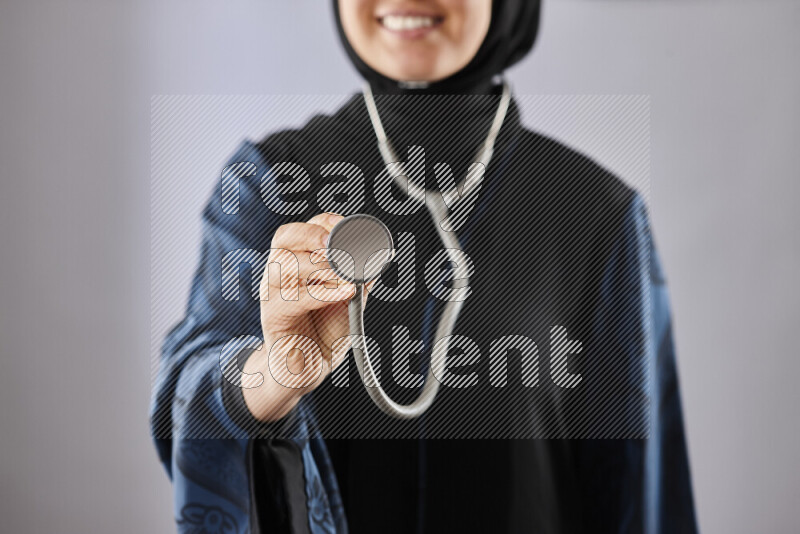 Female doctor wearing an abaya and medical attire in different positions