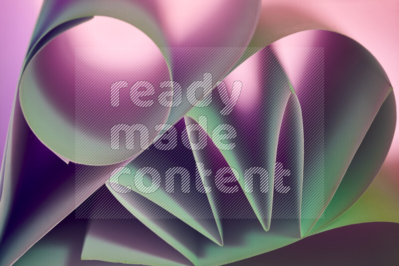 An artistic display of paper folds creating a harmonious blend of geometric shapes, highlighted by soft lighting in green and purple tones