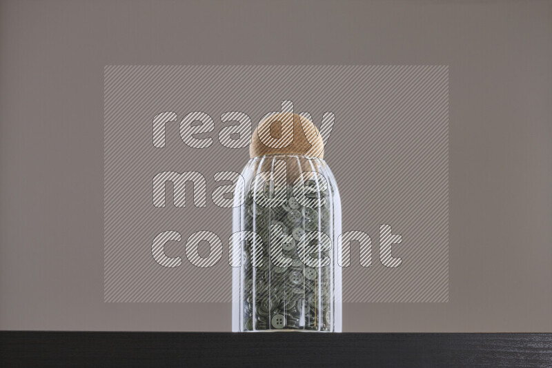 أزرار متنوعة في وعاء زجاجي علي خلفية سوداء